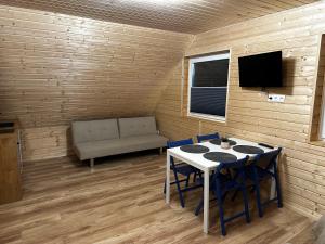 a room with a table and chairs and a couch at Apartamenty pod Witoszą in Staniszów