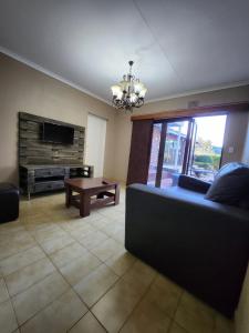 a living room with a couch and a table at FM GUEST LODGE Comfort, Tranquility & Peace of Mind in Johannesburg