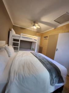 a bedroom with a large white bed and a bunk bed at FM GUEST LODGE Comfort, Tranquility & Peace of Mind in Johannesburg