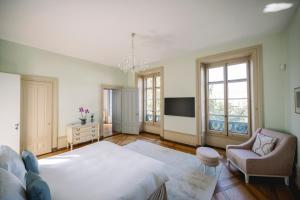 een slaapkamer met een bed en een stoel en een tv bij Le Château de l'Aile in Vevey