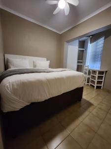 1 dormitorio con 1 cama grande y ventilador de techo en FM GUEST LODGE Comfort, Tranquility & Peace of Mind en Johannesburgo