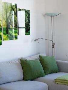 uma sala de estar com almofadas verdes num sofá em Pleasant City Apartment em Graz