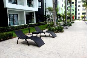 a row of black chairs sitting on a sidewalk at P3 Cozy Stay / Waterpark / 7-8pax Ipoh in Ipoh
