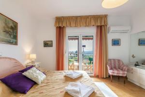 a bedroom with a bed and a door with a balcony at Amazing Villa Chrysanthi with private pool in Heraklion in Epáno Váthia