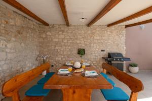 a dining room with a wooden table with blue cushions at Villa 1399 in Hreljići