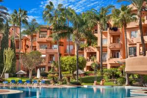 - une vue sur un complexe avec des palmiers et une piscine dans l'établissement Oasis de Marbella, à Marbella