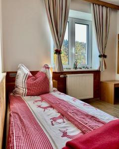 a bedroom with a bed with a red and white blanket at Central Kitz Apartments in Kitzbühel