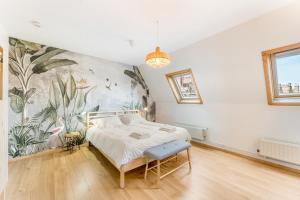 布魯日的住宿－Werf72 - Bruges，卧室配有一张床,墙上挂有绘画作品