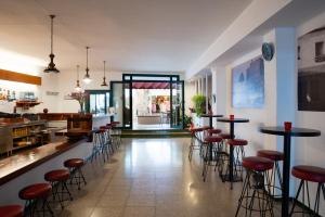 a bar with stools and tables in a restaurant at Hostal el Ranxo in Cadaqués