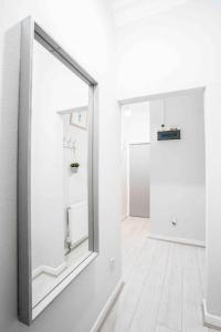 a mirror on the wall in a white room at Cheerful Flat In Moseley With Free Parking in Birmingham