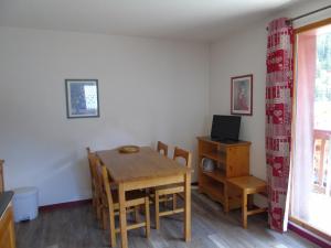 a dining room with a table and chairs and a television at Appartement Valfréjus, 2 pièces, 6 personnes - FR-1-561-18 in Valfréjus