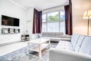 a living room with a couch and a table at Cheerful Flat In Moseley With Free Parking in Birmingham