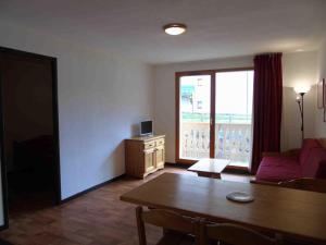 a living room with a table and a window at Appartement Valfréjus, 3 pièces, 6 personnes - FR-1-561-20 in Valfréjus