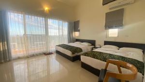 a hotel room with two beds and a window at Tamowan in Donghe