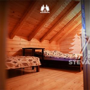 Habitación con cama en una cabaña de madera en Vikendica Stevanovic, en Doboj