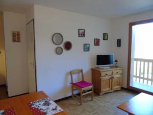 een woonkamer met een stoel en een televisie op een kast bij Appartement Valfréjus, 2 pièces, 4 personnes - FR-1-561-19 in Valfréjus