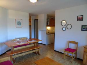een woonkamer met een tafel en een keuken bij Appartement Valfréjus, 2 pièces, 4 personnes - FR-1-561-19 in Valfréjus