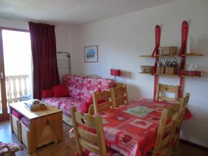 - un salon avec un canapé rouge et une table dans l'établissement Appartement Valfréjus, 3 pièces, 6 personnes - FR-1-561-28, à Valfréjus