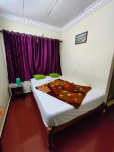 a bedroom with a bed with a blanket on it at Munnar Kaippalli Budget Homestay in Munnar