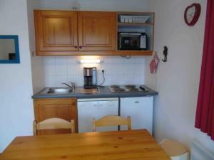 a kitchen with a sink and a table with chairs at Appartement Valfréjus, 2 pièces, 4 personnes - FR-1-561-36 in Valfréjus