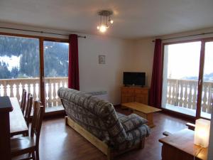 a living room with a couch and a table and a television at Appartement Valfréjus, 4 pièces, 8 personnes - FR-1-561-45 in Valfréjus
