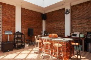 a room with a brick wall and a bar with stools at The Lavana Sasandu Gunung Salak Bogor 