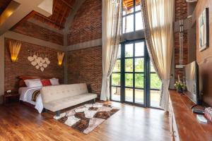 a bedroom with a bed and a brick wall at The Lavana Sasandu Gunung Salak Bogor 