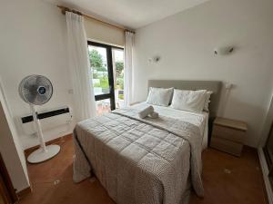 1 dormitorio con 1 cama con ventilador y ventana en Casa Da Maria, en Albufeira
