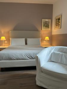 een slaapkamer met een wit bed en een bank bij Agriturismo Il Belvedere in Palazzago