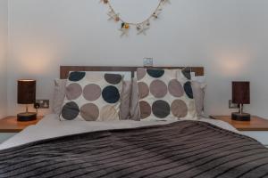 a bedroom with a bed with pillows and two lamps at 46 Meadow View in Woolacombe