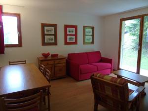 a living room with a red couch and a table at Appartement Valfréjus, 2 pièces, 6 personnes - FR-1-561-78 in Valfréjus