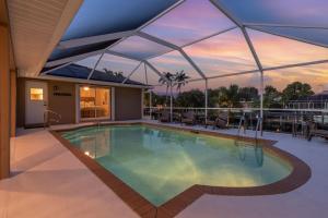a large swimming pool with a roof at Gulf Access, Heated Pool, Bikes, Kayaks - Comfort on the H2O - Cape Coral - Roelens Vacations in Cape Coral