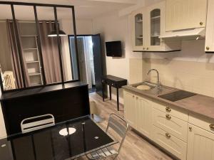 a small kitchen with a table and a sink at Studio AIX LES BAINS in Aix-les-Bains