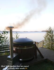 a hot tub grill on a dock next to the water at SResort Saunas - hot tub, palju in Imatra