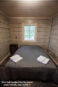 Ce lit se trouve dans une petite chambre dotée d'une fenêtre. dans l'établissement SResort Saunas - hot tub, palju, à Imatra