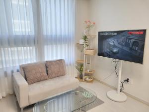 a living room with a chair and a flat screen tv at DAON STAR BnB j6 in Daegu