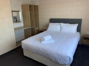 a bedroom with a bed with a towel on it at Harbour View 49 Urch Street Unit 6 in Geraldton