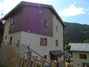 a house with a purple roof and a wooden fence at Appartement Valfréjus, 3 pièces, 8 personnes - FR-1-561-95 in Modane