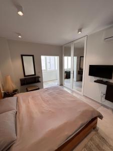 a bedroom with a large bed and a flat screen tv at Luxury Private Room - TV in Paceville