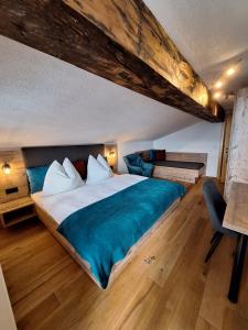 ein Schlafzimmer mit einem großen Bett mit einer blauen Decke in der Unterkunft Ferienwohnung Reicherhof in Sankt Veit im Pongau