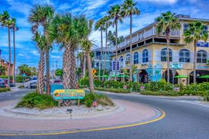 a street with palm trees in front of a building at Island Time-Private Beach Access-Heated Pool-Water Views in Bradenton Beach