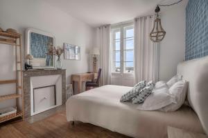 a bedroom with a white bed and a fireplace at Les Hortensias Baie de La Baule -13 in Pornichet