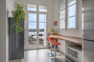 a kitchen with a counter and a table with plants at Les Hortensias Baie de La Baule -13 in Pornichet