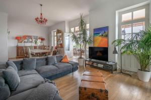 a living room with a couch and a tv at Les Hortensias Baie de La Baule -13 in Pornichet