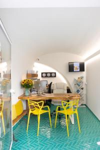 a dining room with yellow chairs and a wooden table at Santa Maria 24 in Monopoli