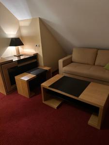 ein Wohnzimmer mit einem Sofa und einem Tisch in der Unterkunft Restauracja i Hotel Oberża Wilczy Głód in Krzyszkowice