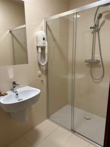 a bathroom with a shower and a sink at Restauracja i Hotel Oberża Wilczy Głód in Krzyszkowice