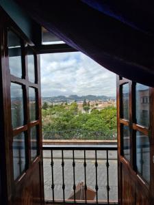 een open raam met uitzicht op een balkon bij Casa Hibiscus Boutique Hotel in Cuenca