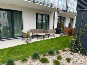 a patio with a table and chairs in a yard at Rezydencja Niechorze 108 Prestige in Niechorze