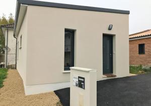 uma casa branca com duas janelas de lado em Aux Pommiers - Poitiers CHU - CAMPUS - La Conciergerie em Poitiers